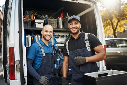 D & D Complete Sewer Service—Two male plumbers standing by their truck in a residential area in Springfield, IL during the summer season.